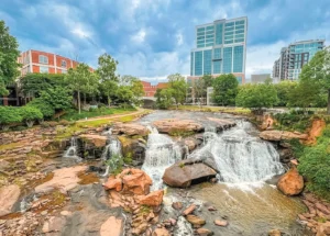 Waterfall At Falls Park On The Reedy Surrounded By Buildings